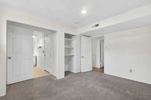 Unfurnished bedroom featuring light carpet and a closet