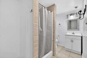 Bathroom featuring vanity, a stall shower, and light tile patterned flooring
