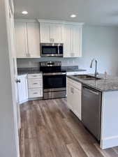 Kitchen featuring granite countertops, soft close hinges, stainless steel appliances, and recessed lighting