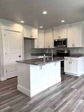 Kitchen featuring granite countertops, soft close hinges, stainless steel appliances, and recessed lighting