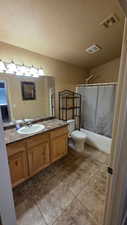 Full bathroom with vanity, shower / tub combo with curtain, a textured ceiling, and light tile patterned floors