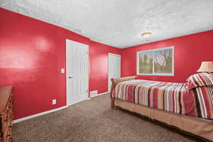 Carpeted bedroom with baseboards and a textured ceiling