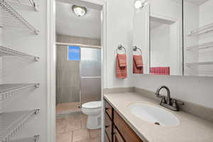 Full bath featuring vanity, a shower stall, and light tile patterned floors