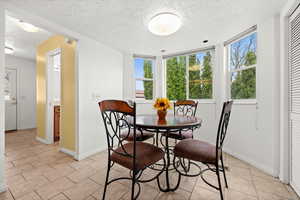 Dining room with a textured ceiling and light tile patterned floors