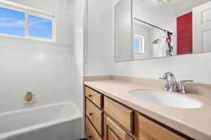 Bathroom featuring vanity, a textured ceiling, and shower / tub combo with curtain