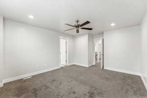 Unfurnished bedroom featuring dark carpet, a ceiling fan, and recessed lighting