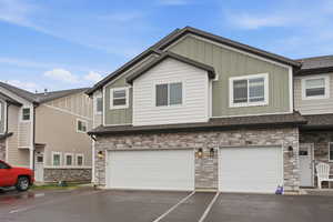 Craftsman house with stone siding, board and batten siding, a garage, and roof with shingles