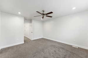 Empty room with recessed lighting, a ceiling fan, and dark colored carpet