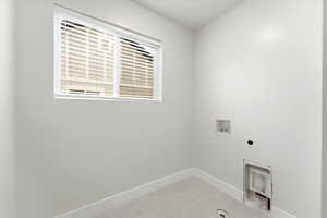 Laundry room with washer hookup, light tile patterned flooring, and electric dryer hookup