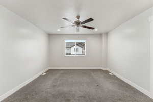 Carpeted empty room featuring a ceiling fan and a textured ceiling