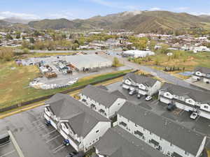 Aerial view of property and surrounding area with mountains and nearby suburban area