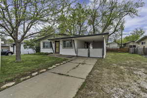 View of front facade with an attached carport and concrete driveway
