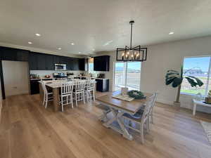 Dining space with light wood-style flooring, hanging lights, and a textured ceiling