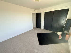 Bedroom with carpet, a closet, and a textured ceiling