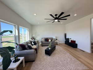Living area featuring light wood-style flooring, a ceiling fan, recessed lighting, and a textured ceiling