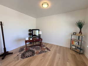 Home office with baseboards and light wood-style flooring
