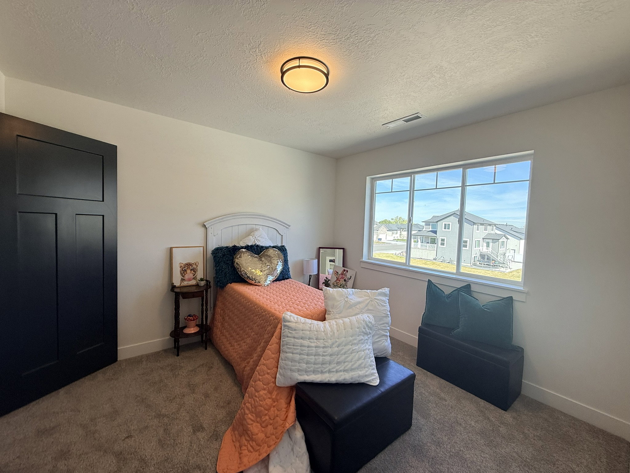 Carpeted bedroom featuring a textured ceiling and baseboards
