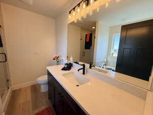Bathroom with vanity, a shower stall, light wood-style floors, and a garden tub
