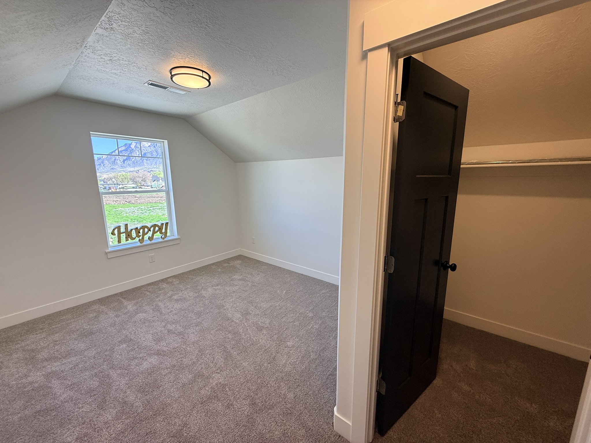 Additional living space featuring a textured ceiling and dark carpet