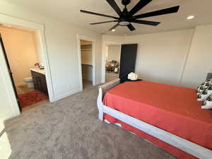 Bedroom featuring a walk in closet, connected bathroom, light colored carpet, a ceiling fan, and recessed lighting