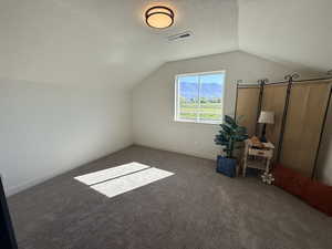 Bonus room with a textured ceiling and carpet flooring