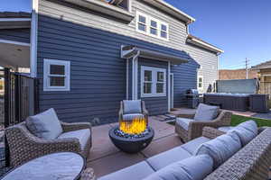 Wooden deck with an outdoor living space with a fire pit, a hot tub, area for grilling, and a patio