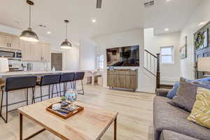 Living room with light wood-type flooring and recessed lighting