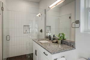 Bathroom featuring vanity and a stall shower