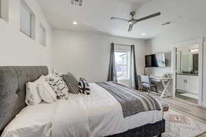 Bedroom featuring light wood finished floors, a ceiling fan, recessed lighting, and connected bathroom