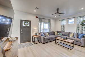 Living area featuring light wood-style flooring, healthy amount of natural light, a ceiling fan, and recessed lighting