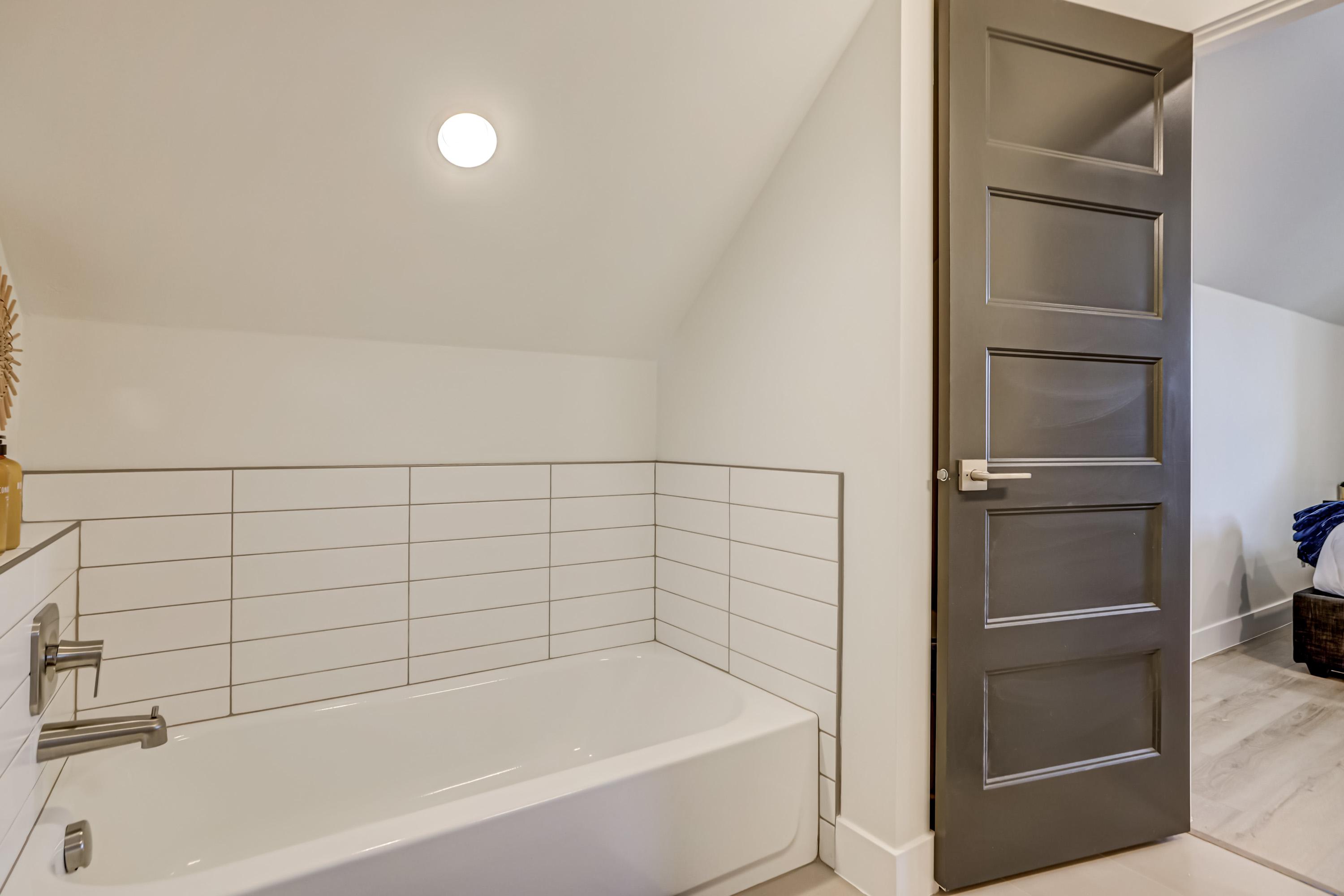 Full bath with lofted ceiling and a bath