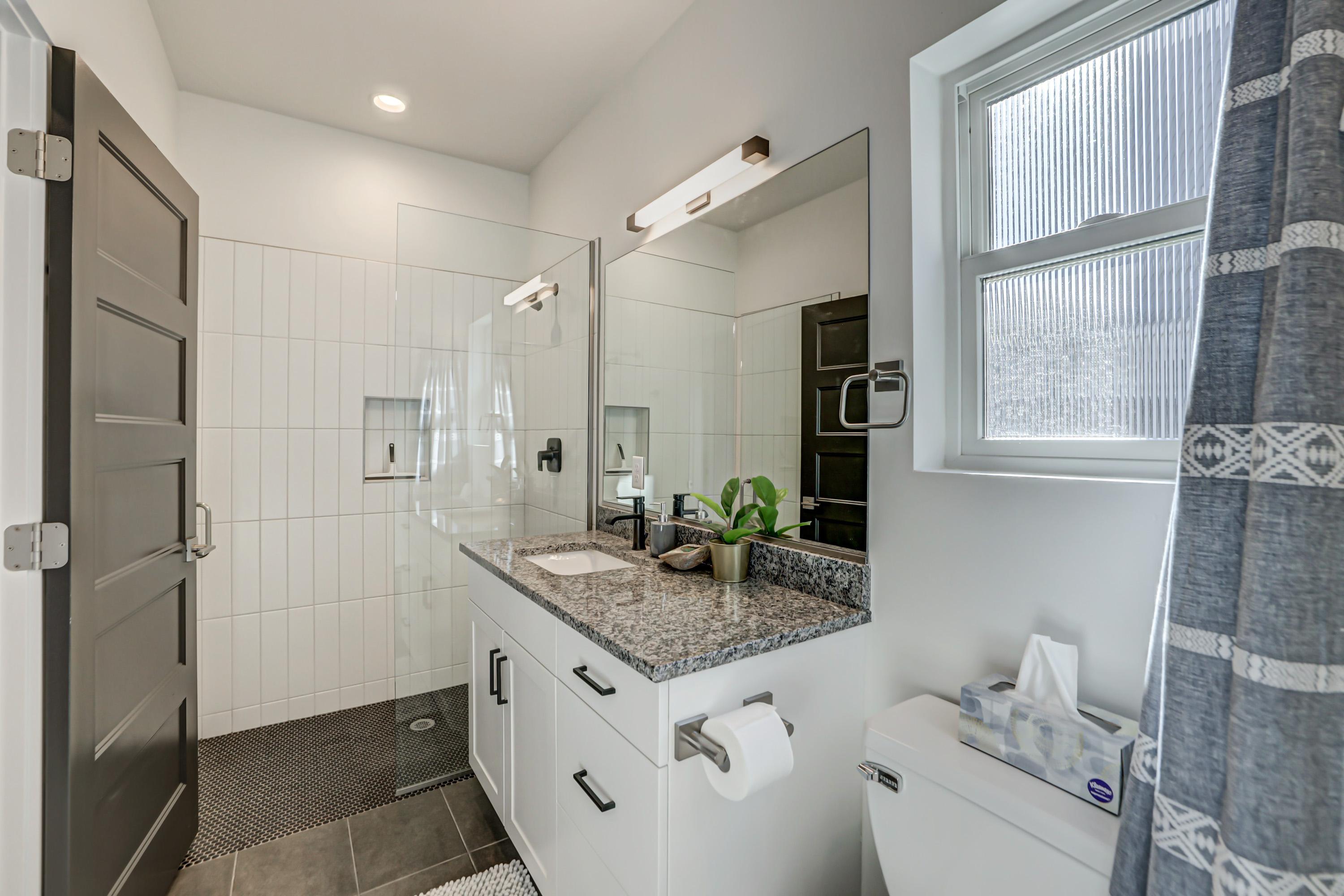 Bathroom with vanity, a stall shower, and dark tile patterned floors