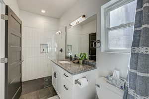 Bathroom with vanity, a stall shower, and dark tile patterned floors