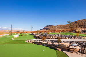 View of property's community with a putting green, a mountain view, and view of golf course