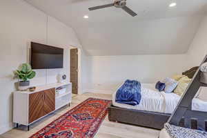 Bedroom with light wood finished floors, recessed lighting, ceiling fan, and vaulted ceiling