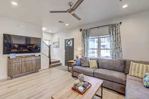 Living room with light wood-style flooring, a ceiling fan, and recessed lighting