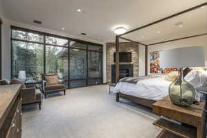 Bedroom featuring expansive windows, light carpet, a fireplace, and recessed lighting