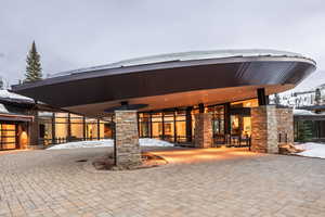 Snow covered property with curved driveway