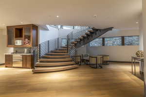Stairs with wood finished floors, recessed lighting, and healthy amount of natural light
