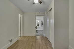 Corridor featuring light wood-style flooring and baseboards