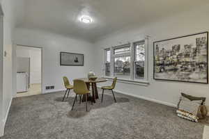 Dining room featuring carpet and a textured ceiling