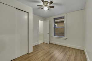 Unfurnished bedroom with light wood-type flooring, a closet, and ceiling fan