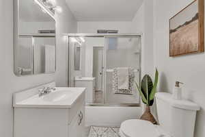 Full bathroom with vanity and enclosed tub / shower combo