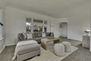 Living area with arched walkways and carpet floors