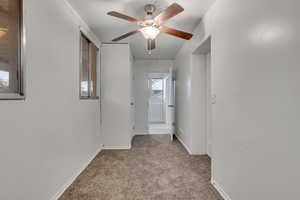 Hall with light colored carpet and baseboards