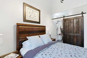 Bedroom with a barn door and wood finished floors