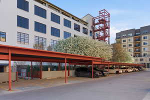 View of apartment building / complex featuring covered parking