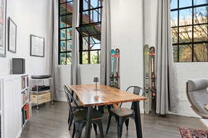 Dining space featuring wood finished floors and a high ceiling