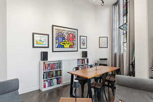 Dining room featuring dark wood-style flooring and baseboards