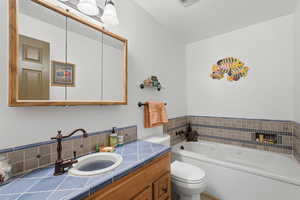 Full bath featuring a garden tub and vanity